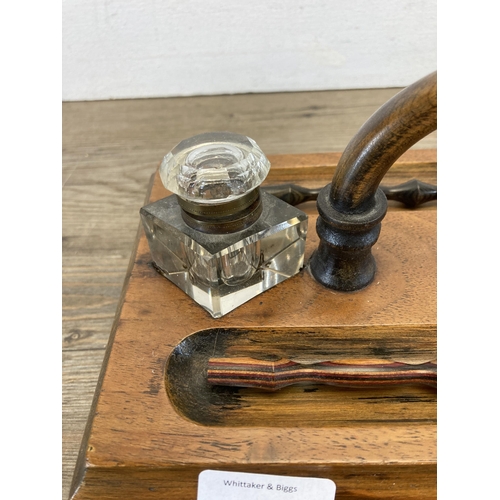 605 - An early 20th century walnut inkwell stand with single drawer and two glass inkwells