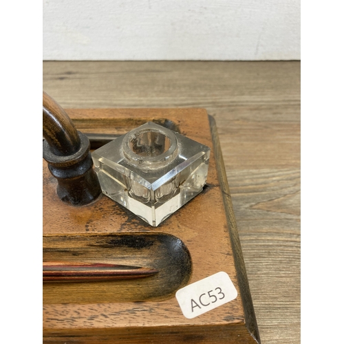 605 - An early 20th century walnut inkwell stand with single drawer and two glass inkwells