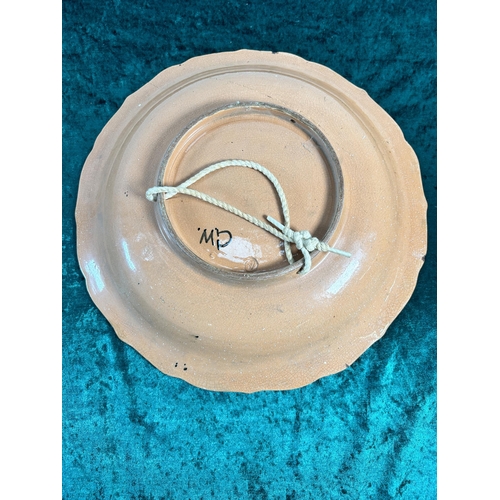 331 - A studio pottery glazed terracotta wall charger, signed GW to reverse - approx. 34cm diameter