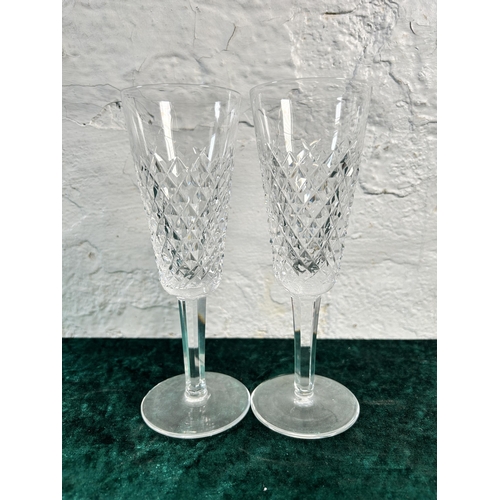 348 - Three pieces of glassware, two Waterford champagne flutes and one Stuart jug