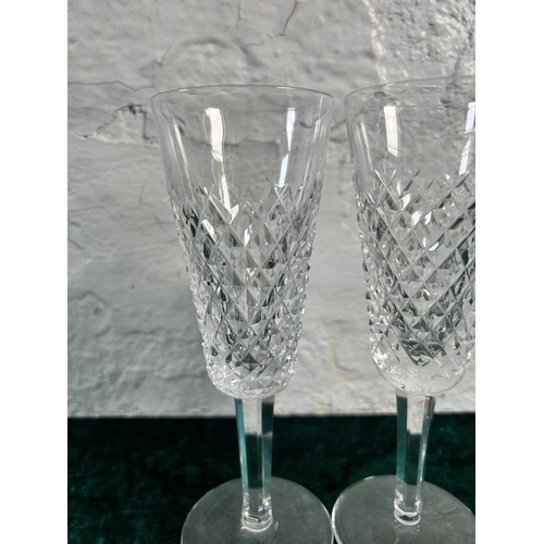 348 - Three pieces of glassware, two Waterford champagne flutes and one Stuart jug