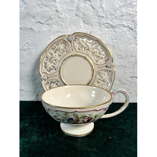 351 - A 19th century hand painted porcelain cup and saucer, signed and stamped to base