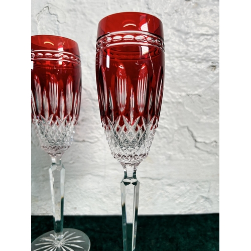 357 - A pair of Waterford Crystal Clarendon ruby glass champagne flutes - approx. 25cm high