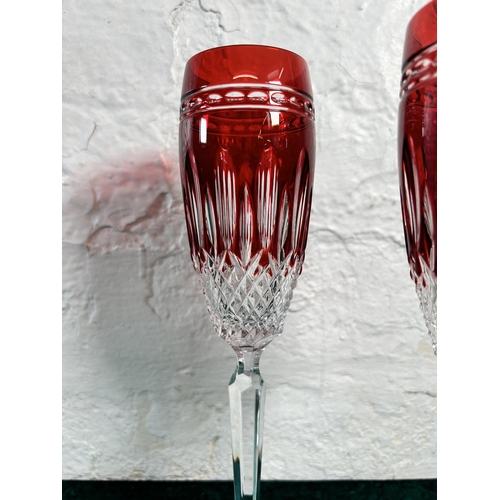 357 - A pair of Waterford Crystal Clarendon ruby glass champagne flutes - approx. 25cm high