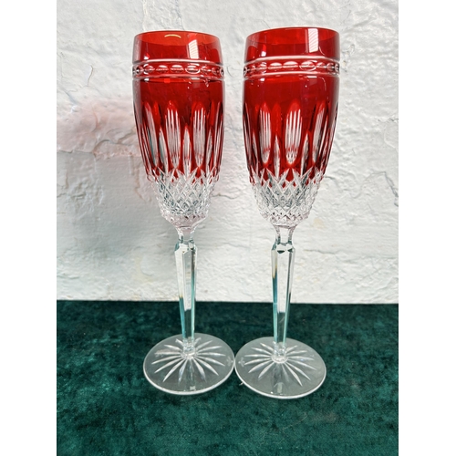 357 - A pair of Waterford Crystal Clarendon ruby glass champagne flutes - approx. 25cm high