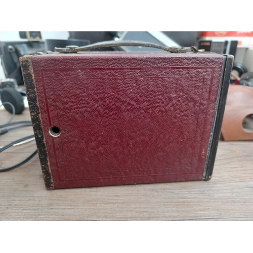 692 - A collection of items to include dark red Kodak Brownie No.2 box camera for 120 film, two cased Fuji... 