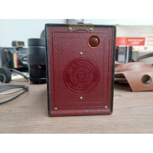 692 - A collection of items to include dark red Kodak Brownie No.2 box camera for 120 film, two cased Fuji... 