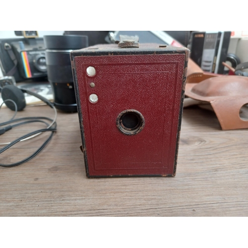 692 - A collection of items to include dark red Kodak Brownie No.2 box camera for 120 film, two cased Fuji... 