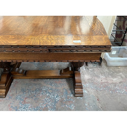 126 - A 1930s carved oak draw leaf dining table with baluster supports and four dining chairs