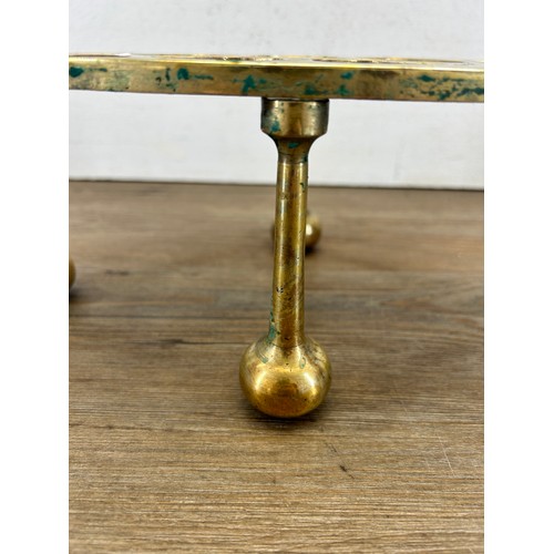 503A - A 19th century brass trivet stand - approx. 13cm high x 29cm wide x 18cm deep