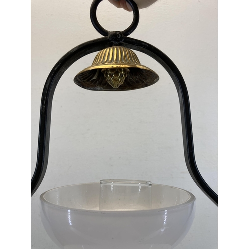 619 - A late 19th/early 20th century brass and wrought iron hanging oil lamp with milk glass shade and cle... 