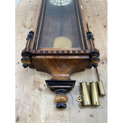 640 - A Victorian walnut cased Vienna wall clock with pendulum and weights - approx. 128cm high x 40cm wid... 