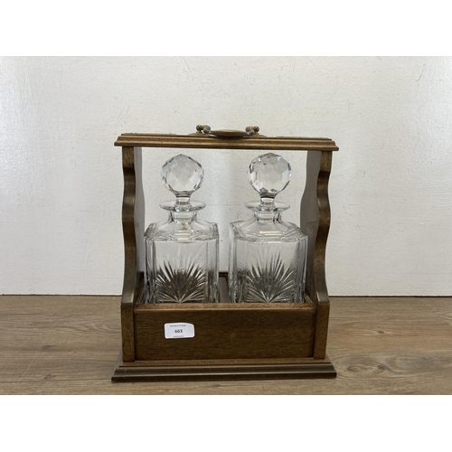 663 - A mahogany and brass decorated tantalus containing two Edinburgh crystal decanters - approx. 32cm hi... 