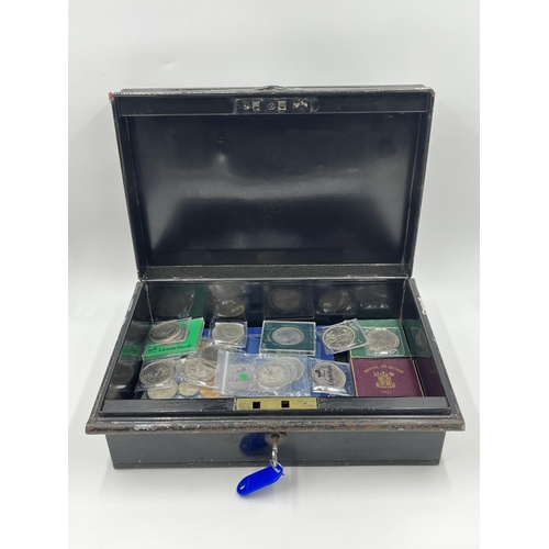 2267 - A cash tin containing a collection of coin sets and commemorative coins to include two 2002 and one ... 