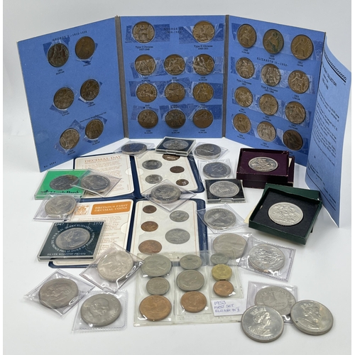 2267 - A cash tin containing a collection of coin sets and commemorative coins to include two 2002 and one ... 