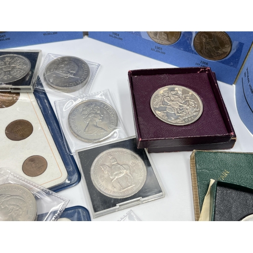 2267 - A cash tin containing a collection of coin sets and commemorative coins to include two 2002 and one ... 