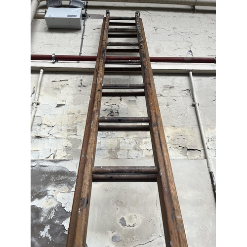 854 - A set of wooden extendable ladders - approx. 12ft long