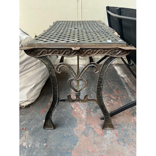 882 - A cast iron garden table - approx. 65cm high x 60cm wide x 116cm long