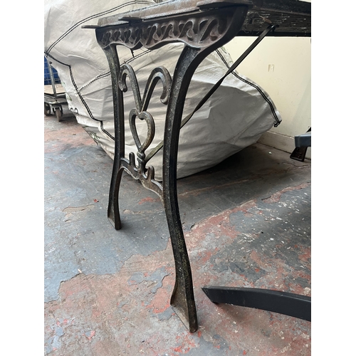 882 - A cast iron garden table - approx. 65cm high x 60cm wide x 116cm long