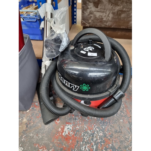 812 - A Numatic Henry cylinder vacuum cleaner with hose and attachments