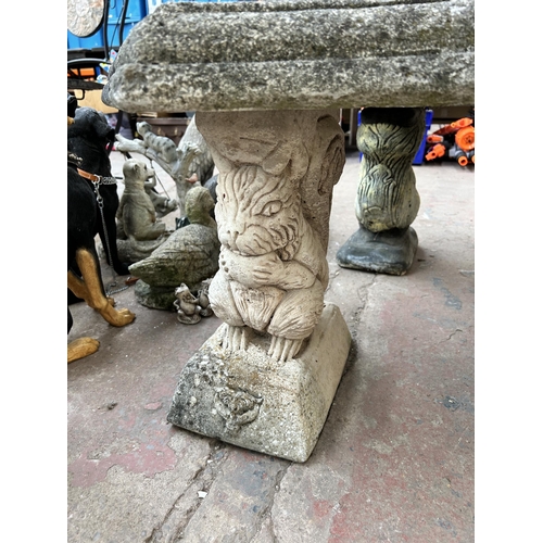 1014 - A cast stone semi circular pedestal garden bench