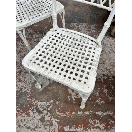 990 - A pair of cast metal and white painted garden chairs