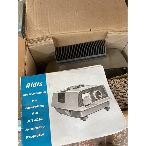 1042 - Four items, two Aldis slide projectors with instructions, one 1960s Tri-ang tubular metal and plasti... 