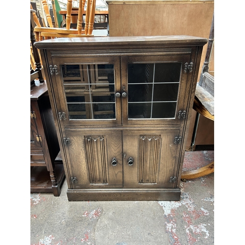 52 - A York Rose carved oak cocktail cabinet with two leaded glass doors, two linenfold doors and fitted ... 