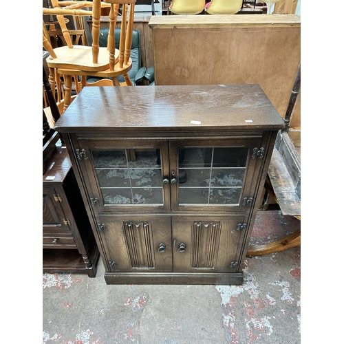 52 - A York Rose carved oak cocktail cabinet with two leaded glass doors, two linenfold doors and fitted ... 