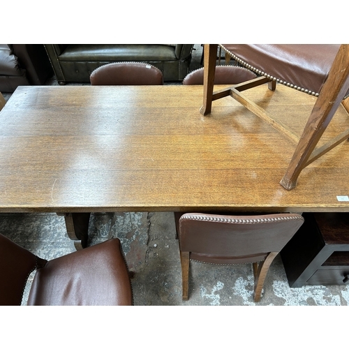 105 - An oak rectangular trestle dining table and five brown leatherette dining chairs