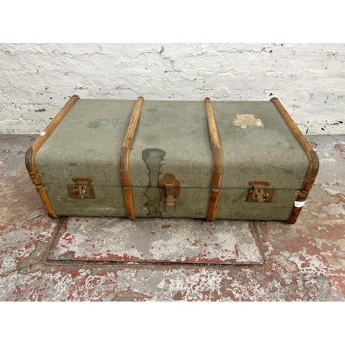 153 - An early 20th century canvas and wooden banded travel trunk