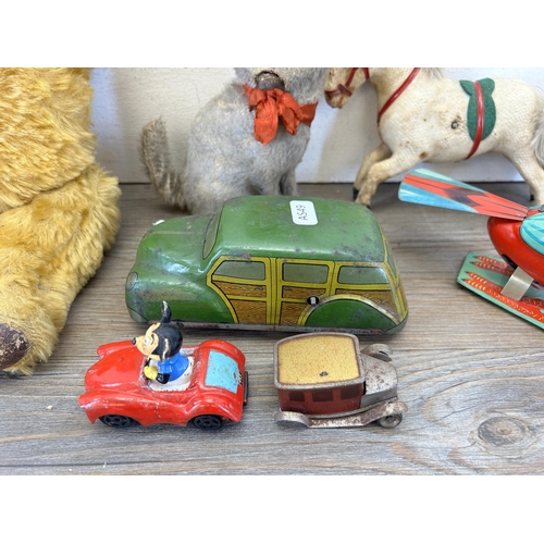 393 - A collection of vintage toys to include three clockwork soft toys, two clockwork tin plate and two m... 