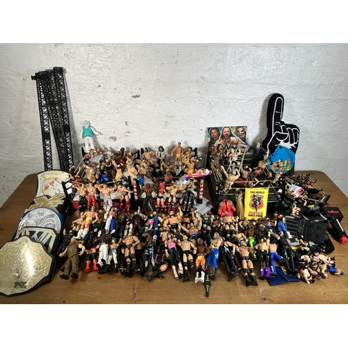 416 - A large collection of WWE wrestling action figurines and accessories to include over one hundred fig... 