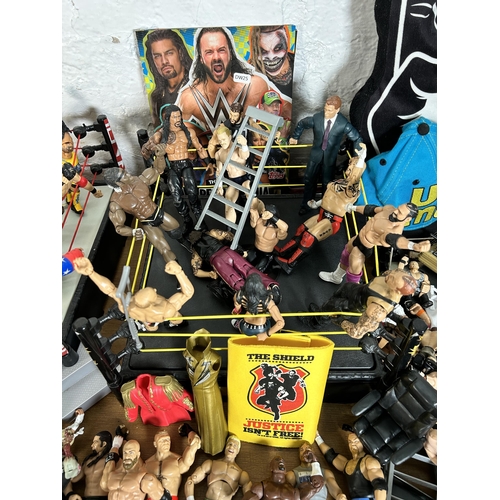 416 - A large collection of WWE wrestling action figurines and accessories to include over one hundred fig... 