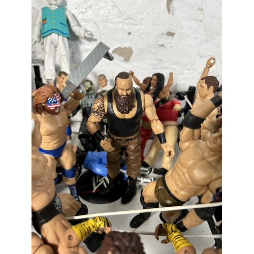 416 - A large collection of WWE wrestling action figurines and accessories to include over one hundred fig... 