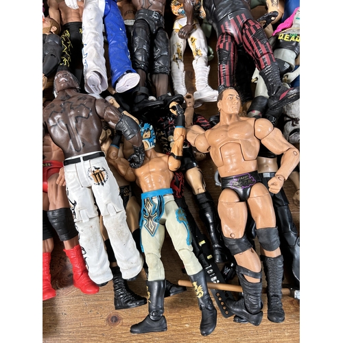 416 - A large collection of WWE wrestling action figurines and accessories to include over one hundred fig... 