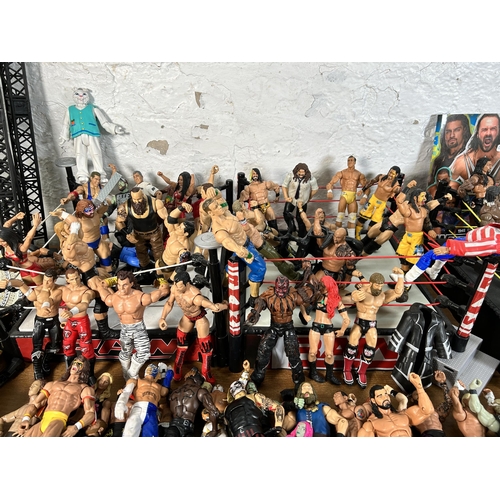 416 - A large collection of WWE wrestling action figurines and accessories to include over one hundred fig... 