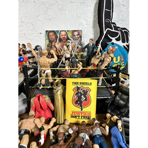 416 - A large collection of WWE wrestling action figurines and accessories to include over one hundred fig... 