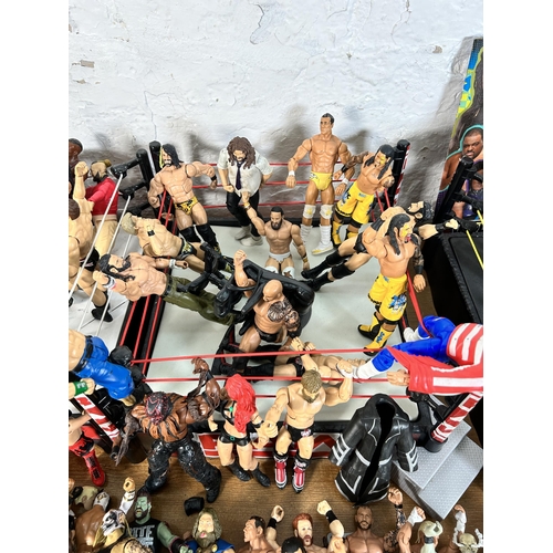 416 - A large collection of WWE wrestling action figurines and accessories to include over one hundred fig... 