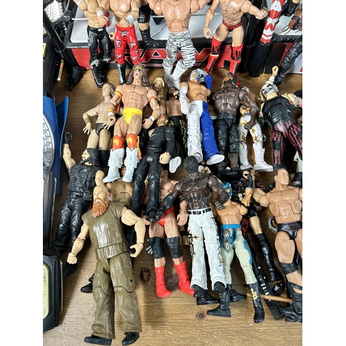 416 - A large collection of WWE wrestling action figurines and accessories to include over one hundred fig... 