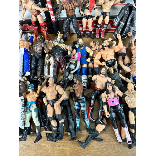 416 - A large collection of WWE wrestling action figurines and accessories to include over one hundred fig... 