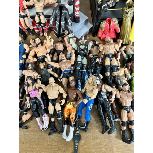 416 - A large collection of WWE wrestling action figurines and accessories to include over one hundred fig... 