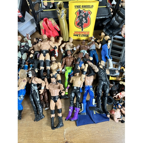 416 - A large collection of WWE wrestling action figurines and accessories to include over one hundred fig... 