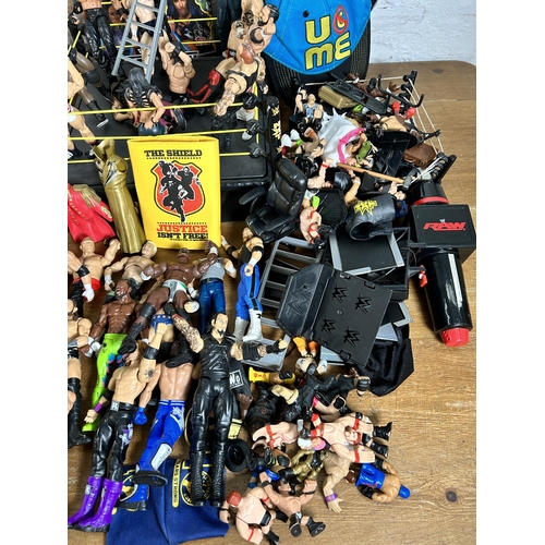 416 - A large collection of WWE wrestling action figurines and accessories to include over one hundred fig... 