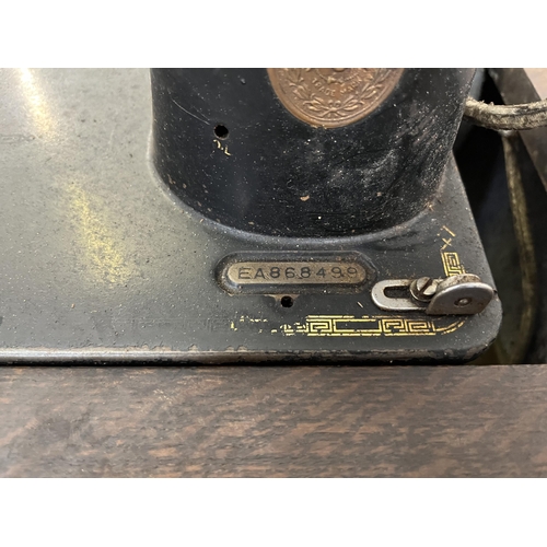 12 - A Singer treadle sewing machine with oak cabinet - serial no. EA868499