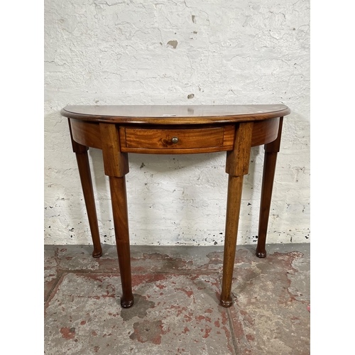 21 - A Georgian style mahogany half moon console table with single drawer