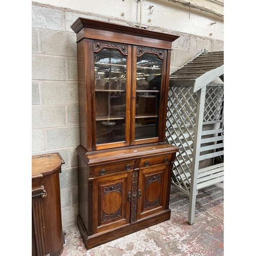 4 - An Edwardian carved mahogany bookcase with two upper glazed doors, two drawers and two cupboard door... 