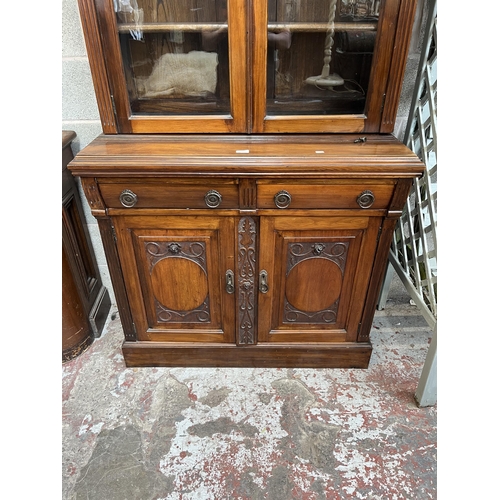 4 - An Edwardian carved mahogany bookcase with two upper glazed doors, two drawers and two cupboard door... 