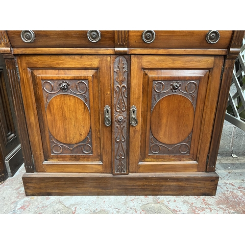 4 - An Edwardian carved mahogany bookcase with two upper glazed doors, two drawers and two cupboard door... 