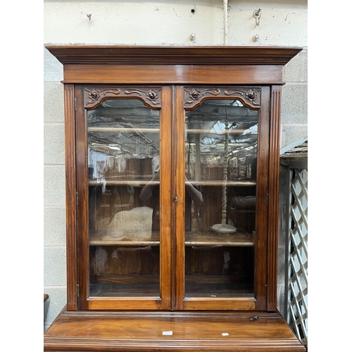 4 - An Edwardian carved mahogany bookcase with two upper glazed doors, two drawers and two cupboard door... 